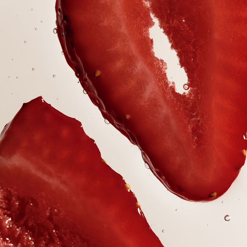 Close-up of two sliced red strawberries on a plain white background.