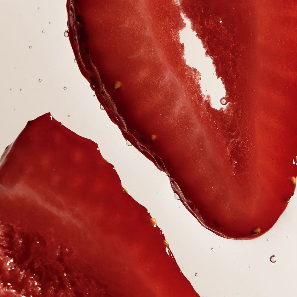 Close-up of two sliced red strawberries on a plain white background.