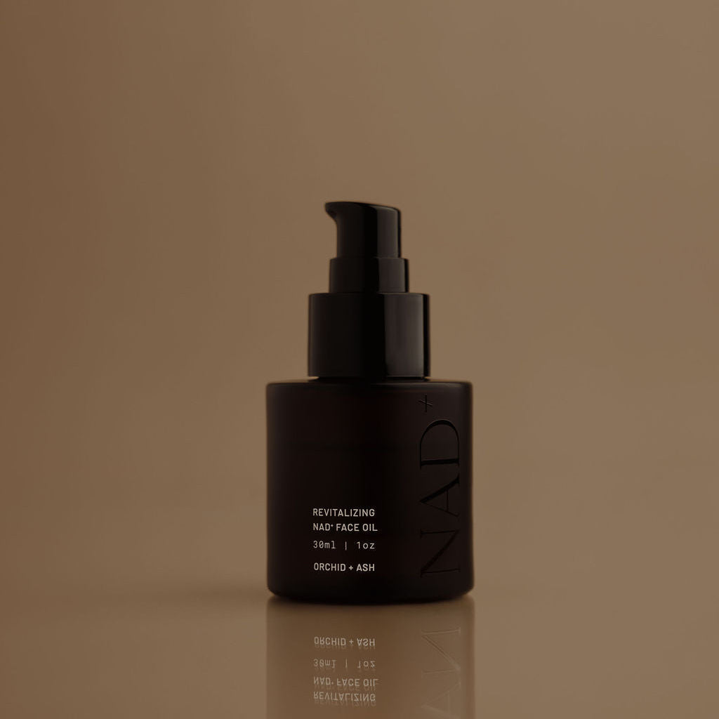 Black skincare bottle with pump on a brown background
