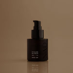 Black skincare bottle with pump on a brown background