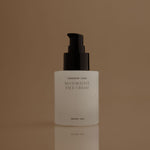 White face cream bottle with black pump on a brown background