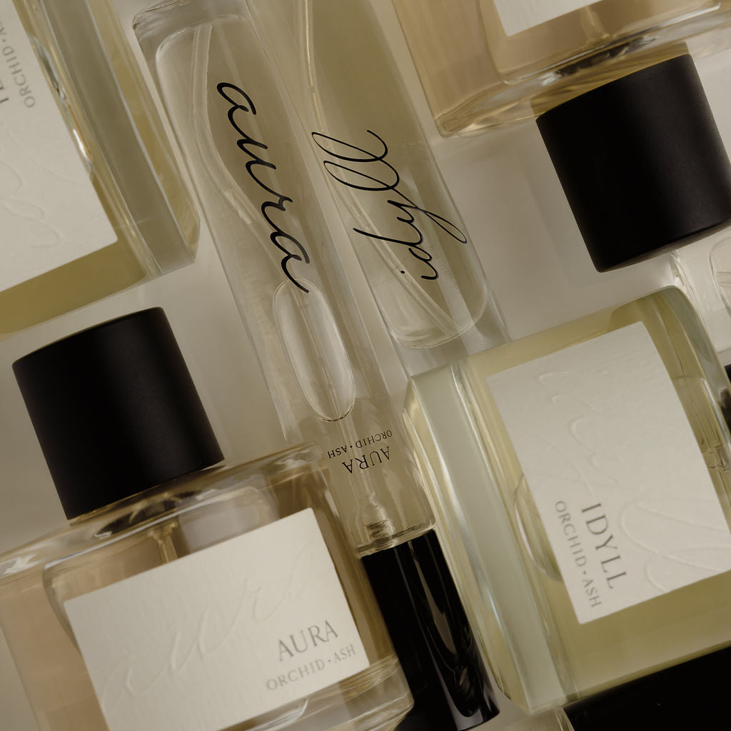 Collection of perfume bottles with visible brand names on a light background