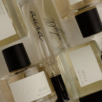 Collection of perfume bottles with visible brand names on a light background