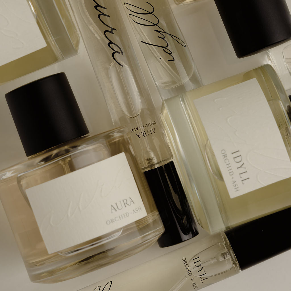 Collection of perfume bottles with visible brand names on a light background