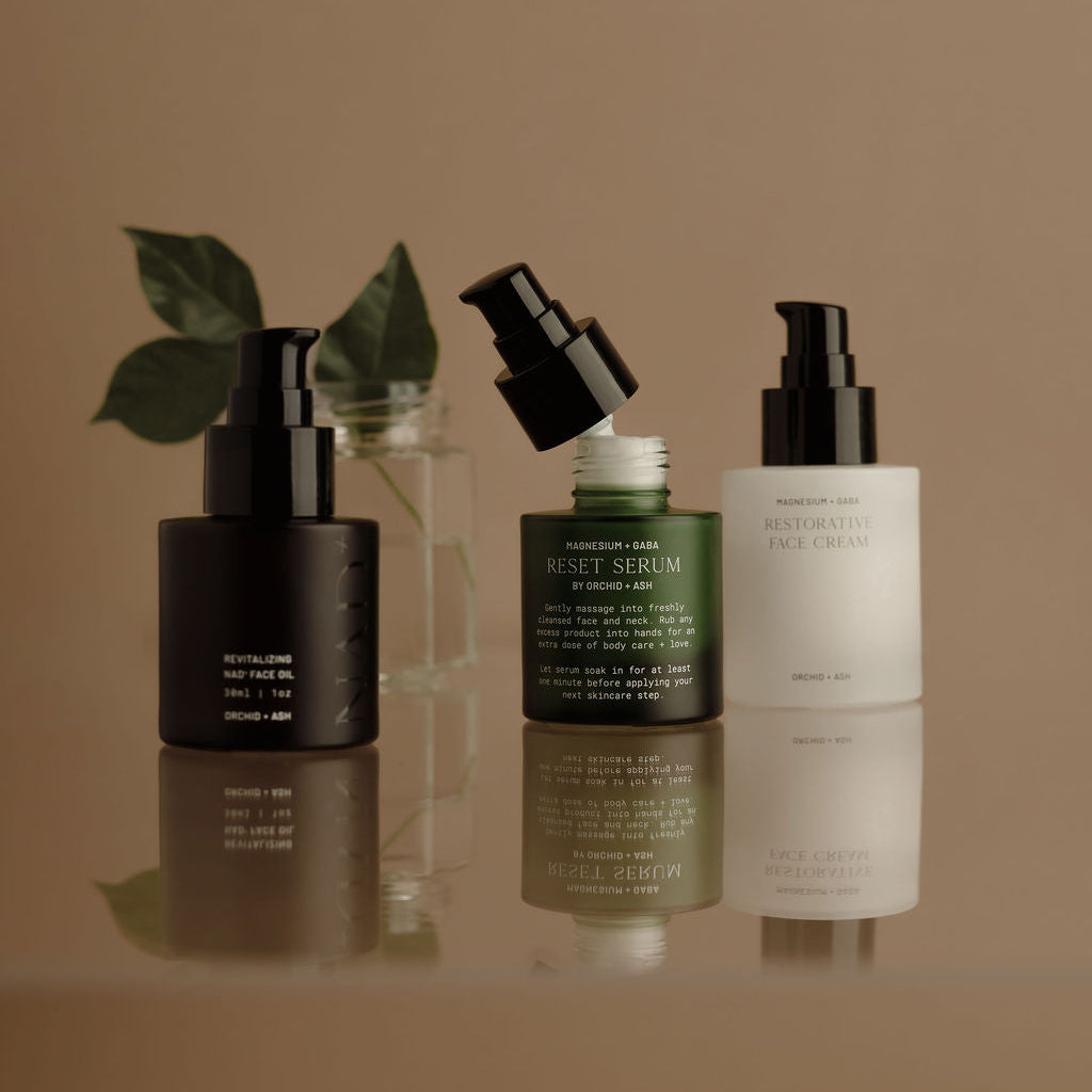 Set of skincare products on a reflective surface with a brown background