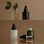 Set of skincare products on a reflective surface with a neutral background