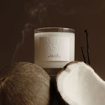 Candle labeled MOONSTRUCK with coconut pieces and smoke in the background