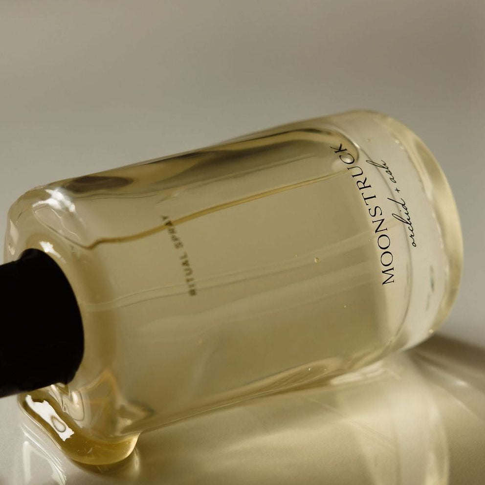 Bottle of Moostuks on a reflective surface with a neutral background