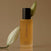 Perfume bottle labeled 'Day Dream' with white flowers on a brown background
