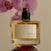 IDYLL Orchid & Ash perfume bottle with pink orchids in the background