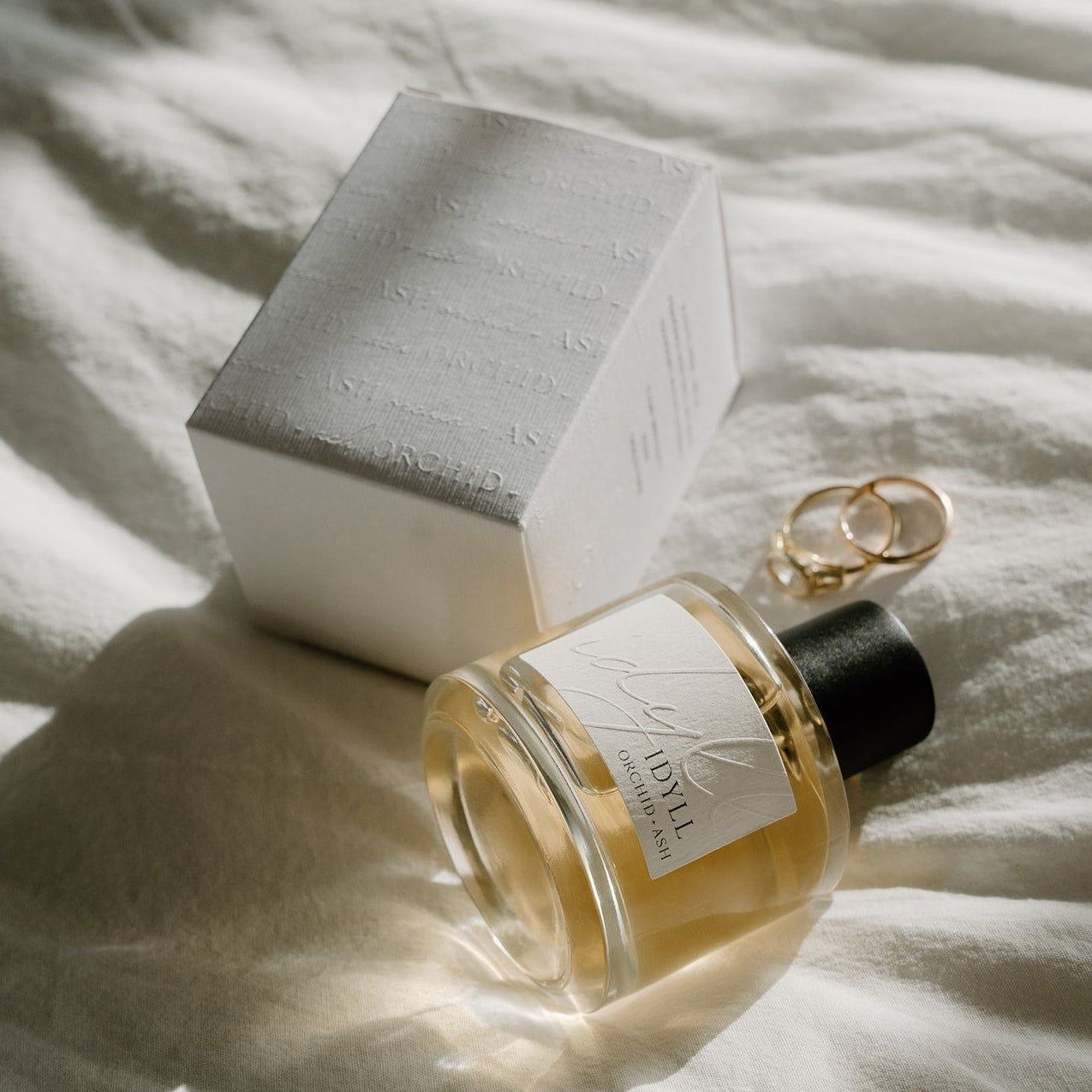 Perfume bottle with a box on a textured surface