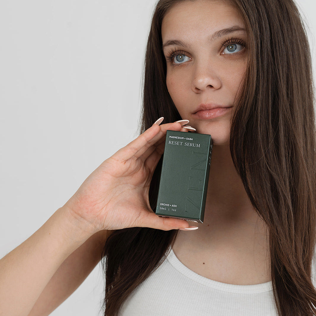 Woman holding a green product box against a white background