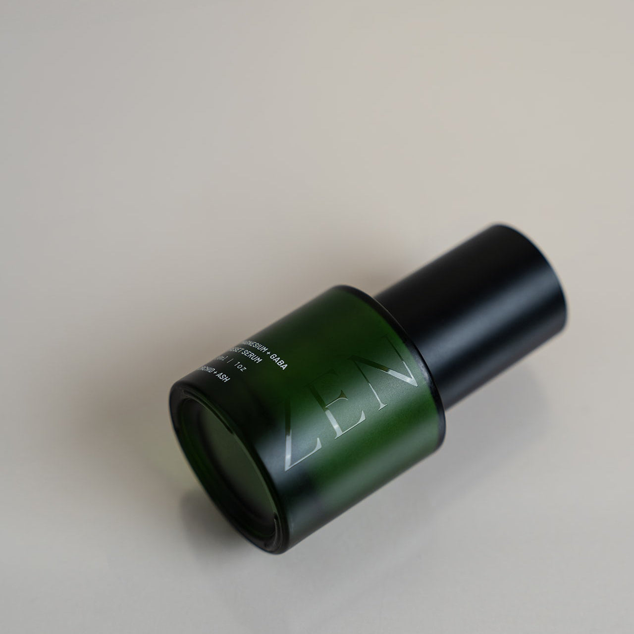 Green and black bottle cap on a beige background