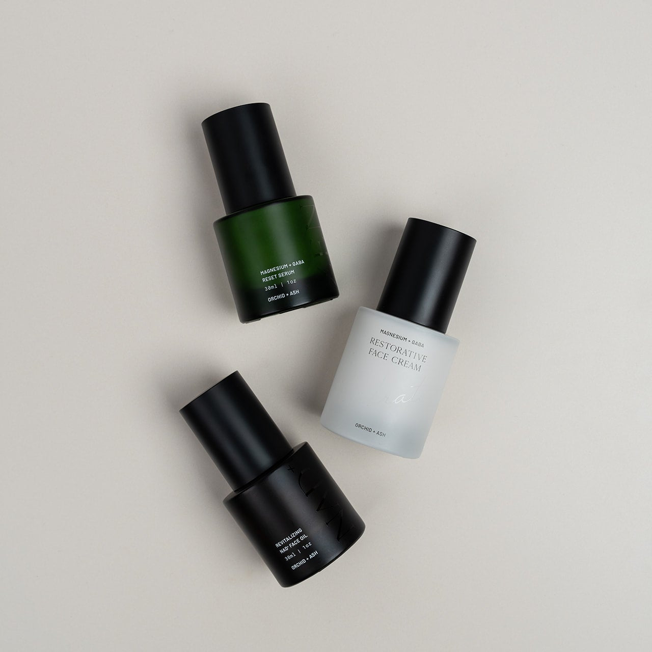 Three skincare bottles on a neutral background
