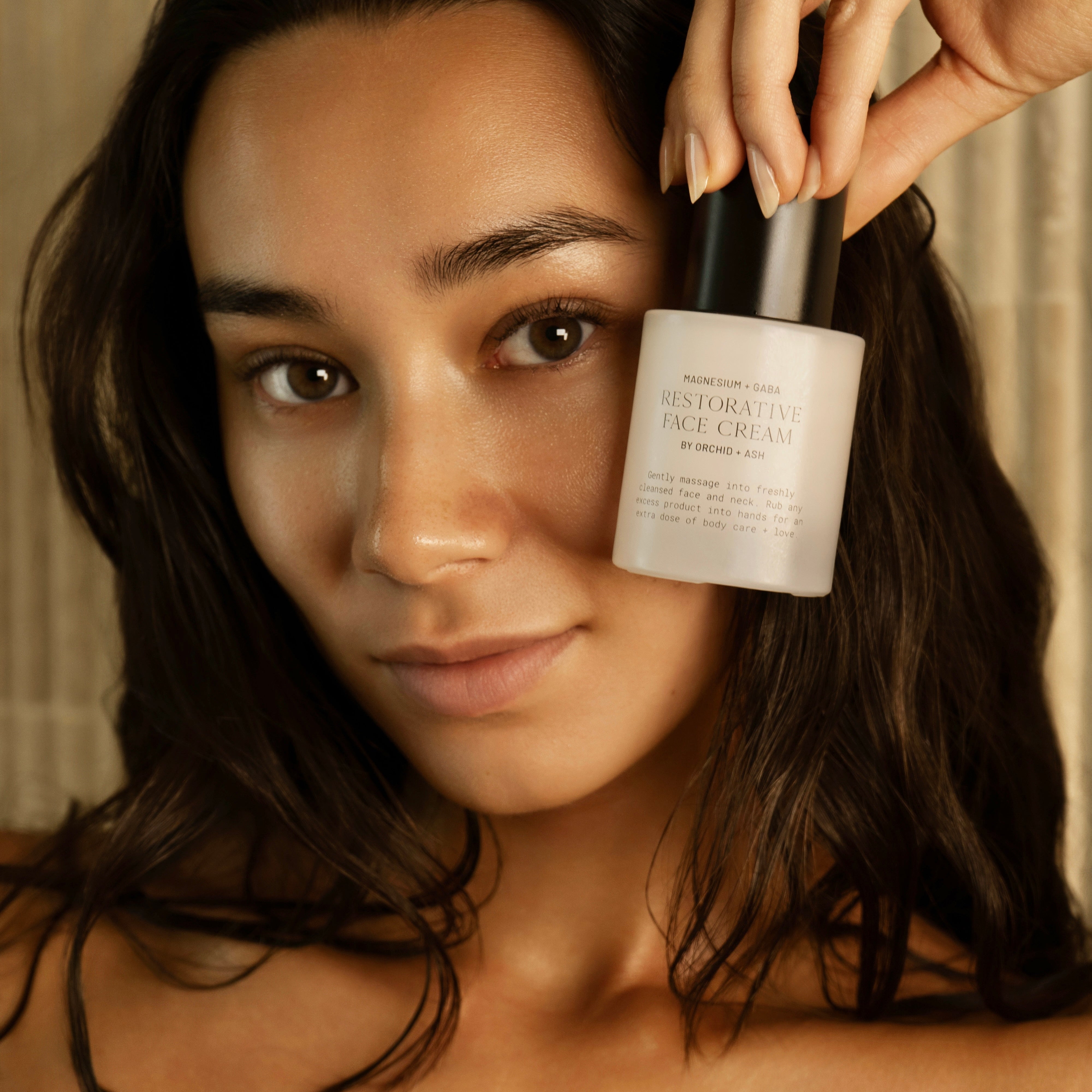 Woman holding a skincare product close to her face